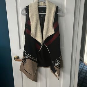Off brand multi-color fall vest with sherpa-like lining at the neckline.